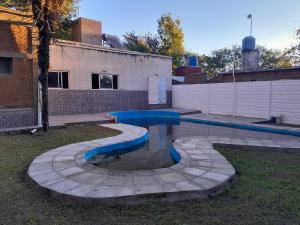 a swimming pool in the yard of a house at Graciela in Villa Las Rosas