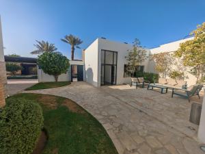 a patio with two benches in front of a building at Al Salateen Villas Resort in Al ‘Ammārīyah