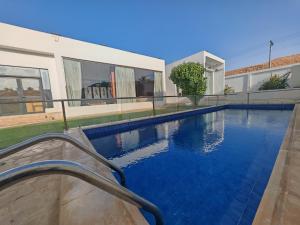 a swimming pool next to a house at Al Salateen Villas Resort in Al ‘Ammārīyah +17 photos