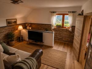 a living room with a couch and a flat screen tv at Haarstubenhäusl Glückskäfer in Frankenfels