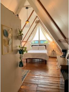 a bedroom with a bed in a attic with a window at Boquete Firefly Inn in Boquete
