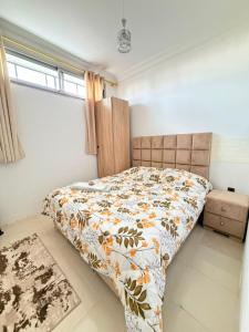 a bedroom with a bed with a floral comforter at Naders in Tangier