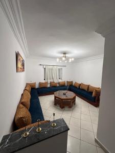 a living room with a blue couch and a table at Appartement Nadin in Martil