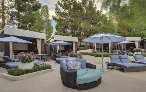 a patio with blue chairs and umbrellas and tables at ARIA Resort & Casino in Las Vegas