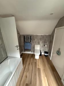 ein Badezimmer mit Toilette und Badewanne in der Unterkunft Sullys in Hastings