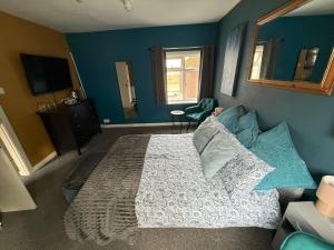 ein Schlafzimmer mit einem großen Bett und blauen Wänden in der Unterkunft Sullys in Hastings