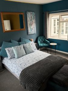 ein Schlafzimmer mit einem Bett, einem Spiegel und einem Stuhl in der Unterkunft Sullys in Hastings