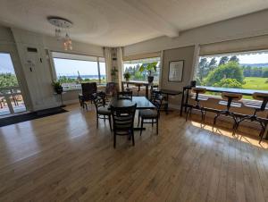 a dining room with a table and chairs and windows at Auberge de nos Aieux in Les Éboulements +43 photos