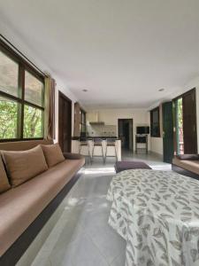 a living room with a bed and a couch at La Maison Nature Relax, Explore, Unwind in Asguine