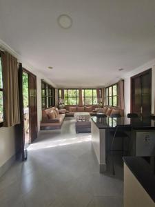 a kitchen and living room with a couch and a table at La Maison Nature Relax, Explore, Unwind in Asguine