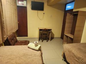 a room with two beds and a table with a television at Hotel Palace in Huancayo