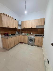 a kitchen with wooden cabinets and a washing machine at Naders in Tangier
