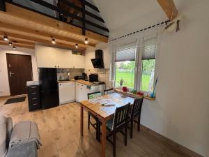 a kitchen and dining room with a table and chairs at Na domek do Pati in Przejma Wielka