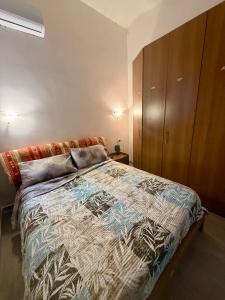 a bedroom with a bed and a wooden cabinet at Casale di Torvaianica in Campo Iemini