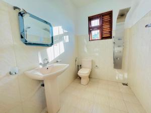 a white bathroom with a sink and a toilet at senlin villa in Galle