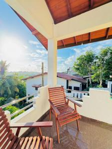 two chairs sitting on the balcony of a house at senlin villa in Galle