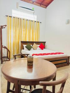 a bedroom with a bed with a table and chairs at senlin villa in Galle