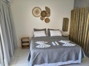 a bedroom with a bed with two towels on it at Pousada Flor De Prado in Prado