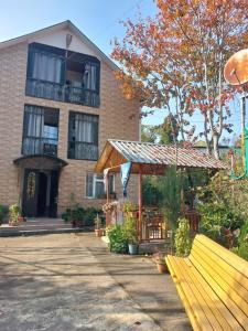 a building with a wooden bench in front of it at Dato's GuestHouse in Makhinjauri
