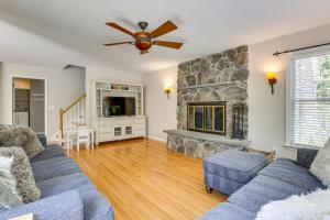 a living room with a blue couch and a stone fireplace at Heated Pool, 6 Acres: Beacon Area Vacation Rental in Lagrangeville
