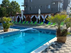 a swimming pool with chairs and a hotel in the background at Hotel Atlantic Costinesti in Costinesti