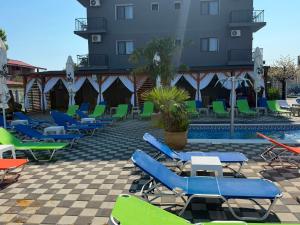a row of lounge chairs next to a building with a pool at Hotel Atlantic Costinesti in Costinesti