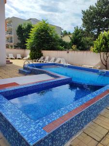 a swimming pool with blue tiles on a patio at Fa Mol in Sunny Beach