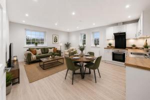 a kitchen and a living room with a table and chairs at Ramsey Rooms in Huntingdon