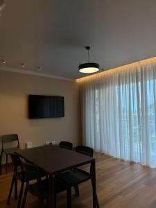 a dining room with a table and chairs and a television at Rrode Apartment Tale Beach in (( Shën Ded Gjoni ))