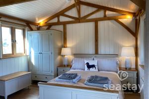 a bedroom with a bed with two lamps on it at The Gatehouse Lodge Farm Stay, Distant Sea Views in Deal