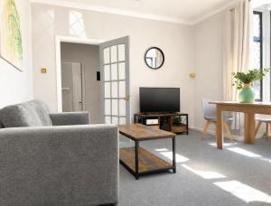 a living room with a couch and a tv at Rose Cottage Edinburgh in Edinburgh