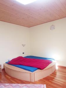 a large bed in a room with a wooden floor at Gästezimmer Casa Lundo 52 - Casa dell'Estate 52 Lundo in Comano