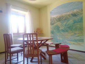 a dining room with a table and chairs and a mural at Gästezimmer Casa Lundo 52 - Casa dell'Estate 52 Lundo in Comano