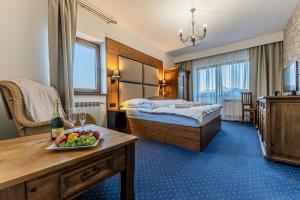 a hotel room with a bed and a table with a bowl of fruit at Penzión Šafrán in Ždiar