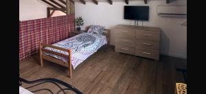 a bedroom with a bed and a dresser with a television at Caress antillaise in Deshaies