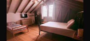 a bedroom with a bed and a chair and a window at Caress antillaise in Deshaies