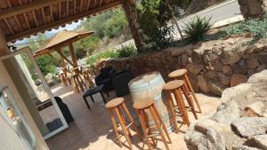 a patio with a bunch of stools and a barrel at Macchie e Fiori in Pianottoli-Caldarello