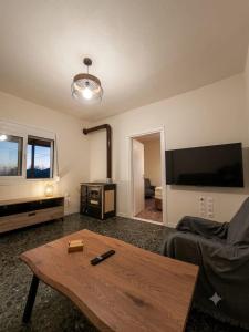 a living room with a coffee table and a flat screen tv at LagonisiSunsetHouse in Kalívia Thorikoú
