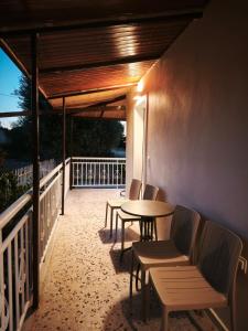 a patio with chairs and a table on a balcony at LagonisiSunsetHouse in Kalívia Thorikoú