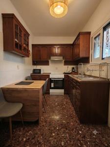 a kitchen with wooden cabinets and a counter top at LagonisiSunsetHouse in Kalívia Thorikoú