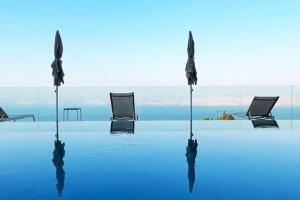 a group of chairs sitting on top of a swimming pool at חופש יהונתן-וילה סלביא עם נוף מטורף בריכה פרטית Hofesh Yehonatan Villa Selavi in Tiberias