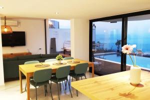 a dining room with a table and chairs in a living room at חופש יהונתן-וילה סלביא עם נוף מטורף בריכה פרטית Hofesh Yehonatan Villa Selavi in Tiberias