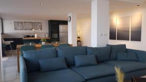 a living room with a blue couch and a kitchen at חופש יהונתן-וילה סלביא עם נוף מטורף בריכה פרטית Hofesh Yehonatan Villa Selavi in Tiberias +65 photos