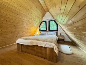 a bedroom with a large bed in a wooden ceiling at Cabana Bucegi View A-Frame Bran in Predeluţ