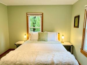 a bedroom with a large white bed with two lamps at Cayuga lake cottage with private lake access in Washingtonville