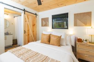 a bedroom with a large white bed and a window at S'more Memories-Cold Plunge, Sauna, Hot Tub Wellness Retreat in Campton +49 photos