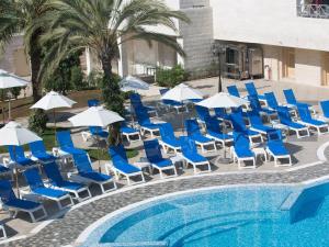 a group of chairs and umbrellas next to a pool at Crowne Plaza Amman by IHG in Amman