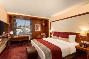 a hotel room with a large bed and a desk at Crowne Plaza Amman by IHG in Amman