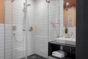 a bathroom with a glass shower and a sink at ipartment Leverkusen @HOME by Best Western in Leverkusen +83 photos