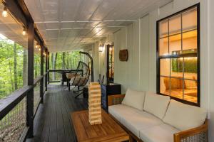 a screened porch with a couch and a table at S'more Memories-Cold Plunge, Sauna, Hot Tub Wellness Retreat in Campton